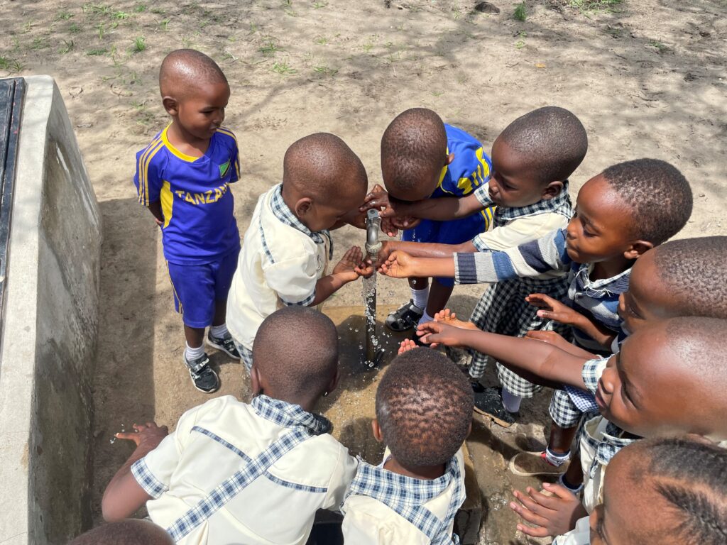 Skolebørn drikker ved den nye vandpost i Bagamoyo, Tanzania.