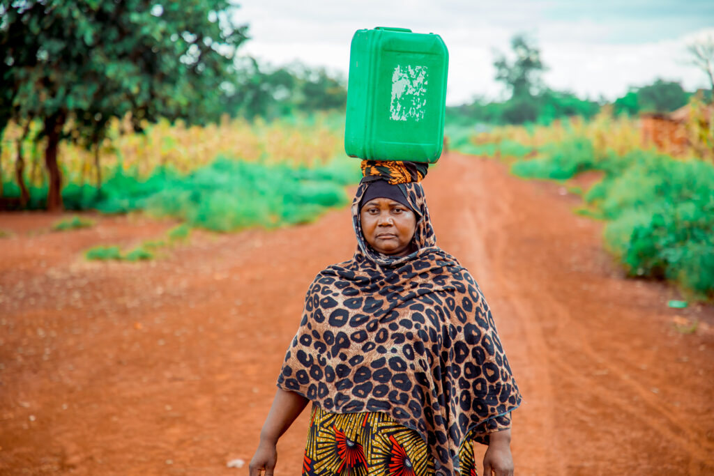 Ashura walking with jerry can