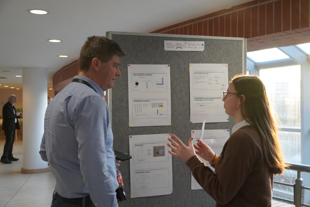 Young woman presenting her physics project to a male jury member.